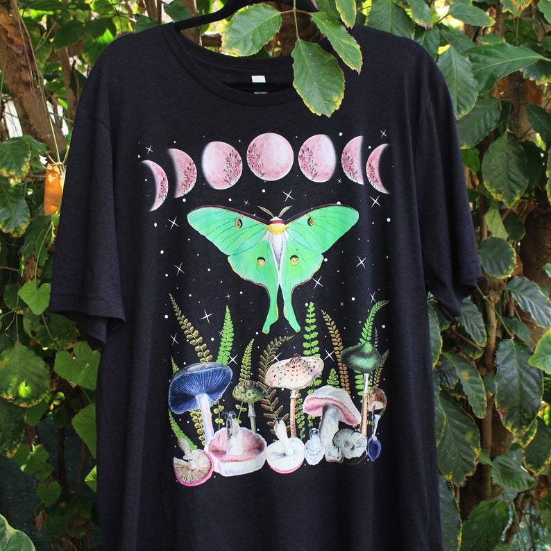 May include: Black t-shirt with a green luna moth, pink moon phases, and mushrooms printed on the front.