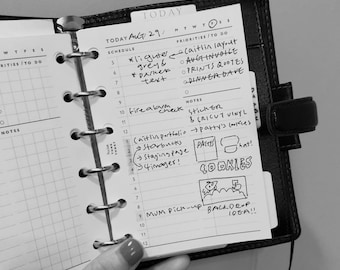 May include: A black and white planner with a daily schedule for August 29th. The planner has a list of priorities and notes for the day, including "Caitlin layout", "Aug invoice", "Prints quotes", "Dinner Dave", "Fire alarm check", "Sticker & Cricut vinyl", "Patty's cookies", "Caitlin portfolio", "Starbucks", "Staging page", "4 imager!" and "Mum pick-up backdrop idea!"