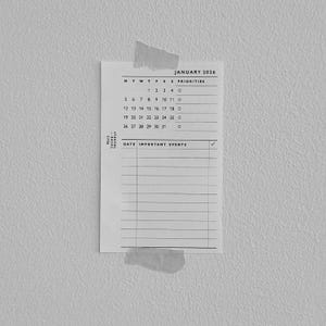 May include: A black and white calendar page for January 2026, taped to a textured gray wall. The calendar includes dates, days of the week, and a section for important events. The text "Mini 5 THANKAY" is printed on the left side.