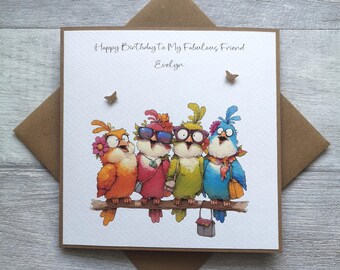 May include: A square greeting card with the text "Happy Birthday to My Fabulous Friend Evelyn" features four colorful cartoon birds perched on a branch. The birds wear sunglasses and accessories. The card is on a brown envelope.