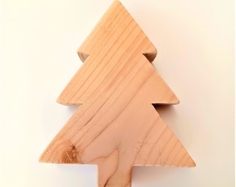 May include: A wooden Christmas tree ornament in the shape of a simple triangle with a flat base. The ornament is made of light brown wood and has a natural wood grain.