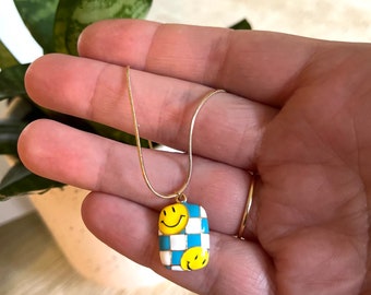 Smiley Face Necklace gold enamel, fun yellow face on white blue checkered pendant on snake chain