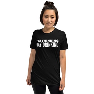 May include: Black short-sleeved t-shirt with white text that reads "I'm thinking day drinking."