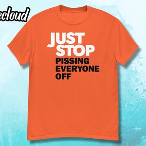 May include: Orange t-shirt with the text "JUST STOP PISSING EVERYONE OFF" in white.