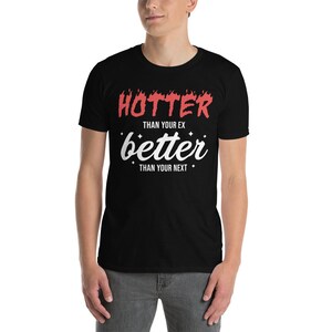 Pu&ograve; includere: Maglietta nera con testo bianco che recita "Hotter than your ex, better than your next" con fiamme rosse intorno alla parola "Hotter".