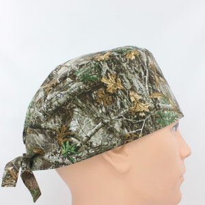 May include: A brown, green, and tan camouflage patterned surgical scrub hat with the text "RealTree EDGE" printed on the side.