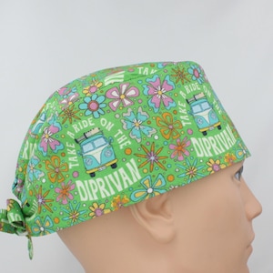 May include: Green surgical scrub hat with a tie back. The hat has a colourful floral pattern with a vintage van and the text "Take a ride on the Diprivan".