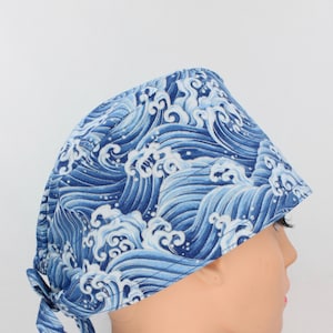 May include: Blue and white patterned surgical scrub hat with a tie at the back. The pattern features a wave design.