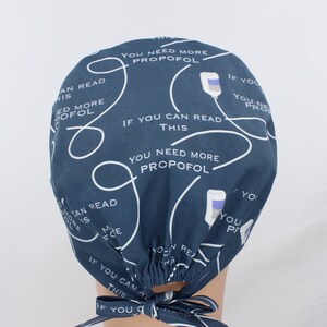 May include: A dark blue scrub hat with a white pattern of IV bags and the text "If you can read this you need more propofol".