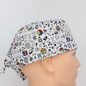 May include: White scrub hat with a black and white print of various science and math symbols, including a Rubik's cube, a light bulb, a brain, and a beaker.