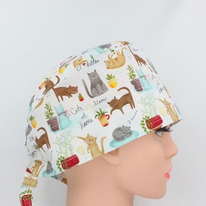Peut inclure: Un bonnet de travail blanc avec un imprimé coloré de chats et de plantes. L'imprimé comprend le texte "J'aime les chatons", "Miaou" et "Les chats à la maison".