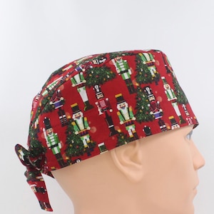 Christmas Nutcrackers on Red Mens Scrub Cap, Mens OR Cap, Medical Cap, Doctor Cap. Enjoy FREE shipping when you spend 35 dollars or more!