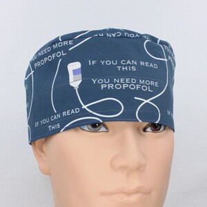 May include: A dark blue scrub hat with a white IV drip design and the text "If you can read this you need more propofol".
