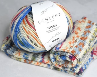 May include: A ball of colorful yarn with a white label that reads "CONCEPT by KATIA MISKA "PREMIUM SOCKS & MORE" "SOFT MERINO WOOL" 105". The yarn is in a multi-colored pattern of blue, red, orange, yellow, and white. Two knitted swatches of the yarn are in the foreground.
