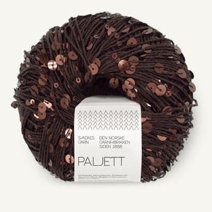 May include: A ball of dark brown yarn featuring integrated metallic copper-colored sequins throughout. A white paper label is wrapped around the center, displaying the text Sandnes Garn, Den Norske Garnfabrikken Siden 1888, and Paljett.