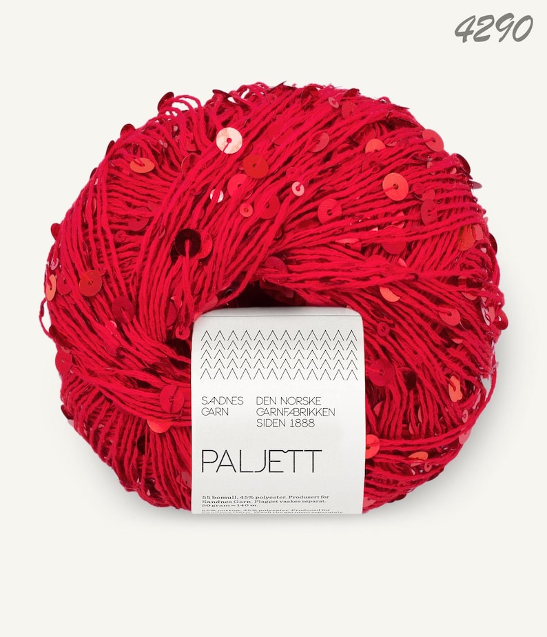 May include: A ball of bright red yarn embellished with numerous small, shiny red sequins. A white paper label is wrapped around the center, featuring the text 4290, Sandnes Garn, Den Norske Garnfabrikken Siden 1888, and Paljett, along with 55% bomull, 45% polyester.