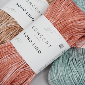 May include: Close-up of three skeins of Katia Concept Boho Lino yarn in shades of brown, coral, and teal. Each skein is wrapped with a white label that reads "CONCEPT by Katia BOHO LINO". The yarn has a textured appearance.