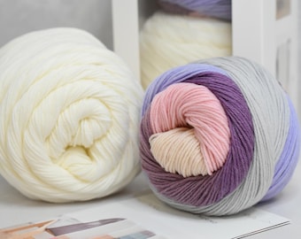 May include: Two balls of yarn, one white and one with stripes of purple, pink, and gray.