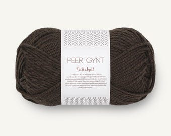 May include: A skein of dark brown yarn wrapped in a white paper label. The label features the text PEER GYNT and Petiteknit, along with a paragraph of printed text and a decorative chevron pattern at the top and bottom edges of the paper band.