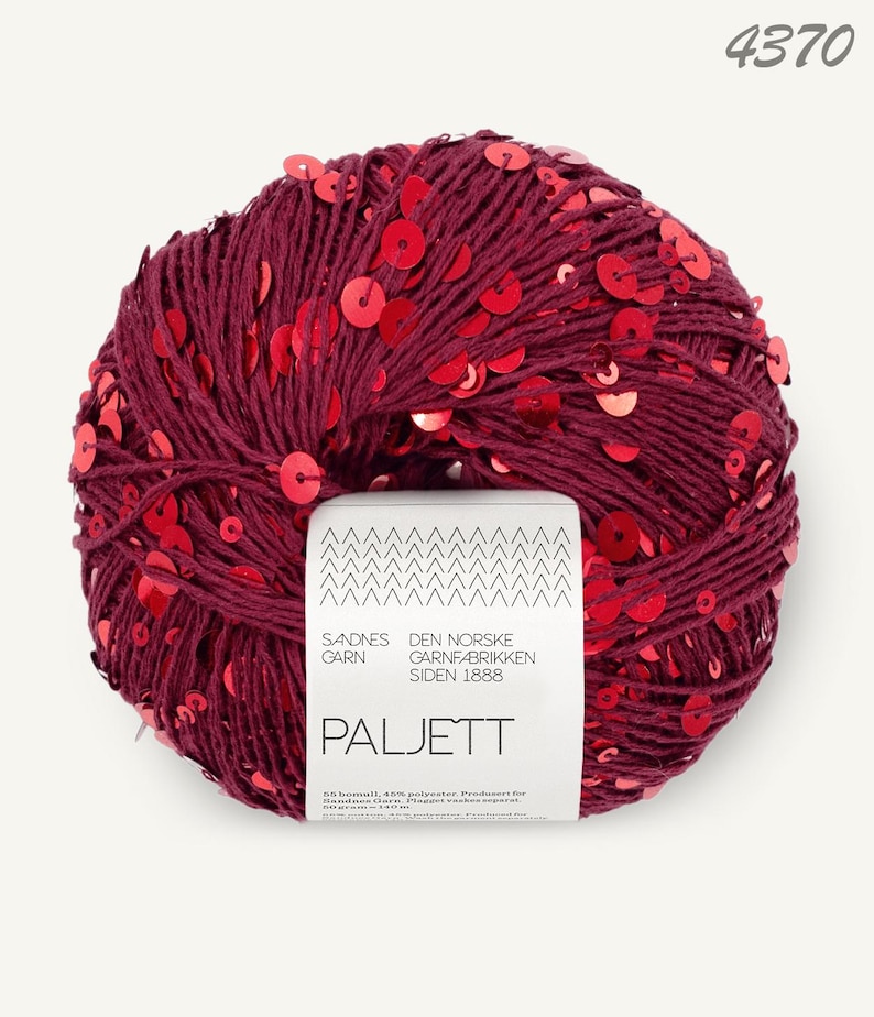 May include: A ball of deep burgundy yarn interwoven with shiny red sequins. A white paper label is wrapped around the center, featuring the text Sandnes Garn, Den Norske Garnfabrikken Siden 1888, Paljett, and the number 4370 in the top corner.
