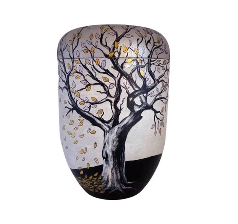 Peut inclure: Une urne blanche avec un arbre noir et des feuilles dor&eacute;es et violettes peintes dessus. L'arbre est au centre de l'urne et les feuilles tombent des branches. L'urne est sur un fond blanc.