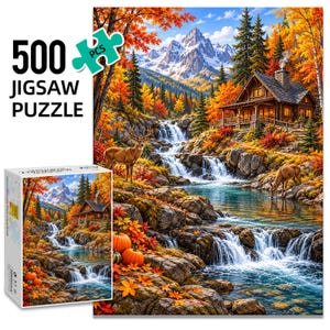 May include: A 500-piece jigsaw puzzle featuring a vibrant autumn landscape with a log cabin, a cascading waterfall, two deer, and orange pumpkins. The box displays the puzzle image, the text 500 JIGSAW PUZZLE, and a puzzle piece icon.