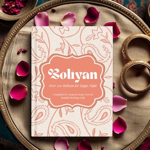 Peut inclure: Un livre intitulé "Boliyan" avec une couverture pêche et un motif cachemire. Le titre est dans une police décorative, avec le texte "Over 500 Boliyan for Jaggo Night". Des pétales roses et des bracelets dorés entourent le livre sur un plateau décoratif.