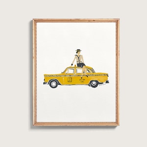 May include: A framed art print featuring a yellow New York City taxi with a black and white checkered stripe. A figure wearing a tan jacket, dark skirt, and hat sits on the roof. The taxi door displays the text NYC TAXI 2,385 in black ink.
