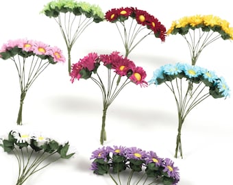 May include: Assortment of 10 bunches of artificial paper daisies in various colors, including green, red, yellow, pink, blue, white, and purple. Each bunch has 6 flowers with yellow centers.
