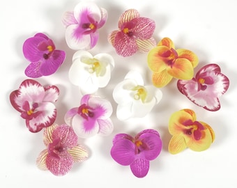 Op de afbeelding: Assortiment van kunstmatige orchideeën in verschillende kleuren, waaronder roze, wit, geel en paars. De bloemen zijn in een cirkel op een witte achtergrond gerangschikt.