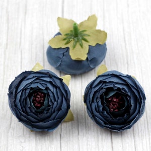 Peut inclure: Trois fleurs en tissu bleu avec un centre vert. Les fleurs mesurent environ 5 cm de diamètre.