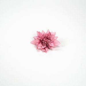 May include: A single pink artificial flower with multiple layers of petals.