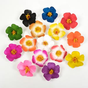Op de afbeelding: Assortiment van 14 kunstmatige hibiscusbloemen in verschillende kleuren, waaronder rood, geel, roze, paars, blauw, groen, oranje en wit. De bloemen zijn in een cirkel op een witte achtergrond gerangschikt.