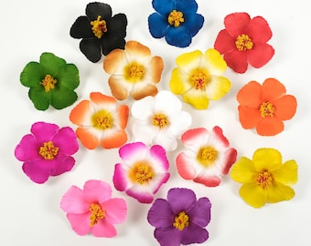 Op de afbeelding: Assortiment van 14 kunstmatige hibiscusbloemen in verschillende kleuren, waaronder rood, geel, roze, paars, blauw, groen, oranje en wit. De bloemen zijn in een cirkel op een witte achtergrond gerangschikt.