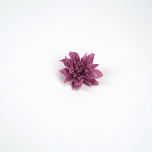 May include: A single, pink, artificial flower with multiple layers of petals.