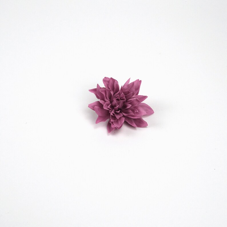 May include: A single, pink, artificial flower with multiple layers of petals.