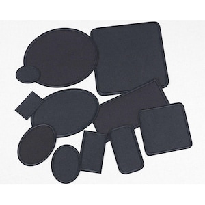 Pode incluir: Uma coleção de patches de feltro preto em várias formas, incluindo ovais, retângulos e quadrados. Cada patch tem uma borda costurada e estão dispostos sobre um fundo branco.