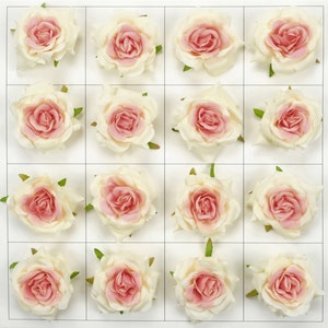 Puede incluir: Un conjunto de 16 rosas artificiales de color crema con centros rosas. Las rosas están dispuestas en una cuadrícula sobre un fondo blanco.