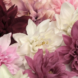May include: A bouquet of artificial flowers in shades of pink, white, and burgundy. The flowers are made of fabric and have a realistic appearance.