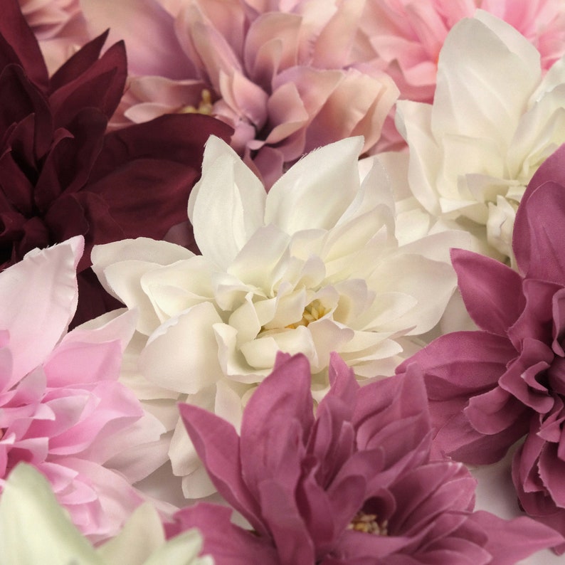 May include: A bouquet of artificial flowers in shades of pink, white, and burgundy. The flowers are made of fabric and have a realistic appearance.