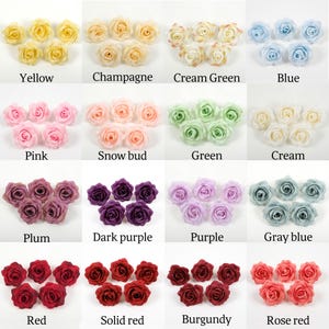 Op de afbeelding: Een verzameling kunstmatige rozen in verschillende kleuren, waaronder geel, champagne, crème groen, blauw, roze, sneeuwknop, groen, crème, pruim, donkerpaars, paars, grijsblauw, rood, effen rood, bordeauxrood en rozerood. Elke kleur is gelabeld.