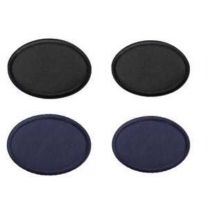 Peut inclure: Quatre écussons ovales vierges, deux noirs et deux bleu marine, sur fond blanc. Les écussons sont en tissu tissé avec un bord cousu.