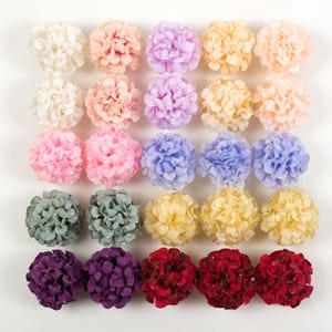 May include: An assortment of artificial flower balls in a range of colours: white, pink, purple, yellow, and red. These decorative floral accents are arranged in neat rows, ideal for crafting or event decoration.