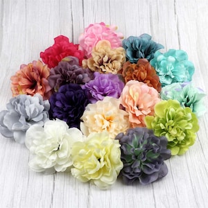 May include: Assortment of 16 artificial flower heads in various colours, including pink, purple, blue, green, and yellow. The flowers are made of fabric and have a realistic appearance.