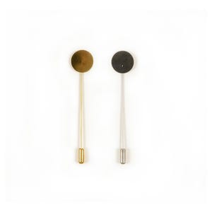 May include: Two lapel pins on a white background. One pin is gold-toned with a matching gold circle and tip. The other pin is silver-toned with a matching silver circle and tip. Both pins have a long, thin stem.