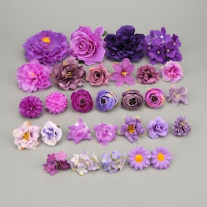 May include: Assortment of purple and lavender artificial flowers in various sizes and styles, including roses, daisies, and hydrangeas.
