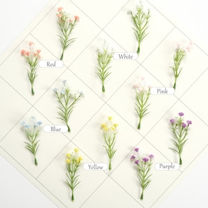 May include: Assortment of artificial flower sprigs in various colors, including red, white, pink, blue, yellow, and purple. Each sprig features small, delicate flowers and green stems.