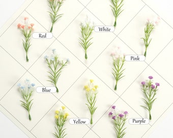May include: Assortment of artificial flower sprigs in various colors, including red, white, pink, blue, yellow, and purple. Each sprig features small, delicate flowers and green stems.