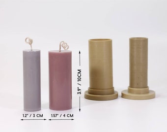 May include: Two pillar candles, one gray and one pink, in plastic molds. The molds are 3.9 inches tall and have a diameter of 1.2 inches and 1.57 inches. The candles are 3 cm and 4 cm tall.