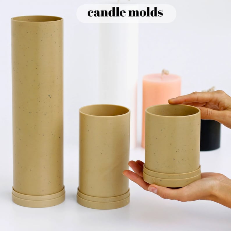 May include: Three brown cylindrical candle molds with a speckled texture. The molds are made of silicone and have a removable base. The text "candle molds" is written in black letters at the top of the image.